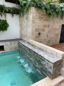 Boutique Hotel Casa Grande في سانتو دومينغو: حمام سباحة مع دش في مبنى