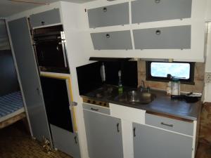 ロヴァニエミにあるWinter caravanの白いキャビネットとシンクのあるキッチン