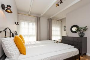 a bedroom with a large bed with yellow pillows at Vaivutės Apartamentai No3 in Darbėnai