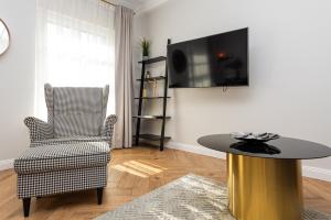 a living room with a table and a chair at Vaivutės Apartamentai No3 in Darbėnai