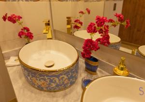 a bathroom with two sinks and flowers in a mirror at Hotel Sinaí SV in Macanal