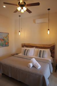 a bedroom with a bed with a ceiling fan at Casa María Dolores, Barrio San Sebastián in Mérida +27 photos