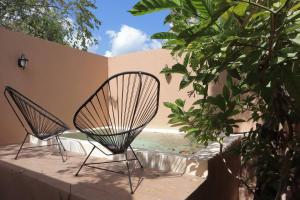 two chairs sitting on a patio next to a pool at Casa María Dolores, Barrio San Sebastián in Mérida