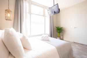 1 dormitorio con cama blanca y ventana en Appart Studio president app3 en Schiedam