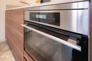 a kitchen with a stainless steel microwave oven at Appart Studio president app3 in Schiedam