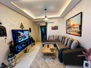 uma sala de estar com um sofá e uma televisão em Splendido appartamento a Gueliz em Marraquexe