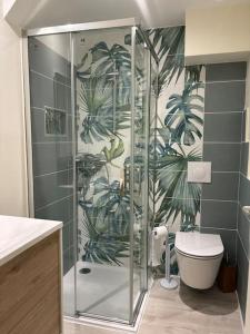 a bathroom with a shower with a toilet and a plant mural at Cocon 2 calme en cœur historique in Périgueux