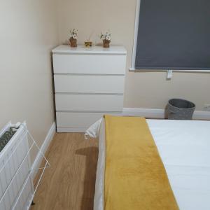 a bedroom with a bed and a dresser and a window at Happy Dreams B in London