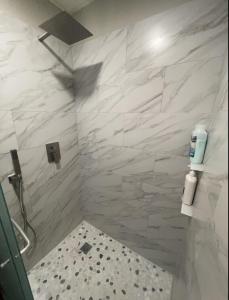 a bathroom with a shower with white marble walls at Beachfront Retreat FREE use of GOLF CART in Surfside Beach