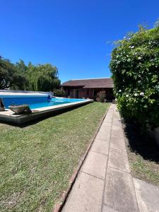 uma piscina num quintal ao lado de uma casa em El_Ceibo_Lobos em Lobos
