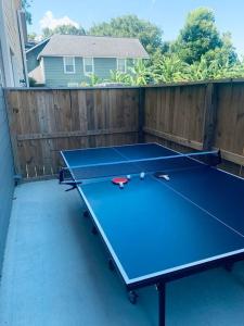 a ping pong table in a backyard with a fence at Stylish 3 BDR House 5 miles to Downtown! in Houston