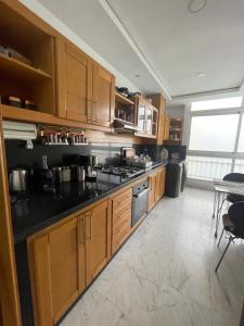 uma cozinha com armários de madeira e bancadas pretas em Appartement haut standing très chic em Casablanca