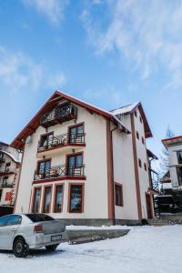 a building with a car parked in front of it at Melody Hotel in Bukovel