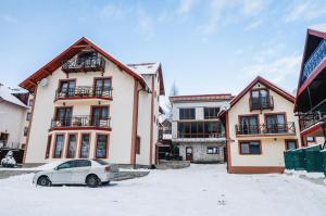 a car parked in a parking lot in front of buildings at Melody Hotel in Bukovel