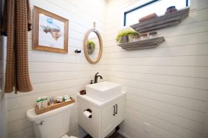 a bathroom with a sink and a toilet and a mirror at The Longhorn Stunning Container Home-In Alpine in Alpine