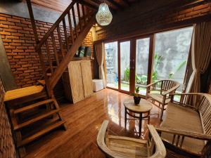 a living room with a staircase and a table and chairs at Jineng Guest house by the swand in Dalung