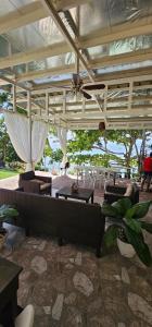 a patio with couches and tables and chairs at MyMi Beach House in Magamomo