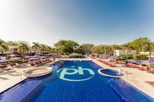 Planet Hollywood Costa Rica, An Autograph Collection All-Inclusive Resort في Culebra: مسبح كبير مع كراسي ومظلات
