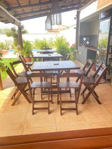 un grupo de mesas y sillas de madera en un patio en Noah Hostel & Chale, en São Miguel do Gostoso