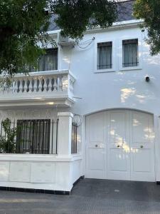 a white house with two garage doors in front of it at En el Corazón de la Quinta. in Villa Marini