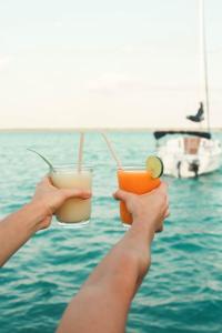 two people holding drinks in their hands near the water at Tortuga Bacalar in Bacalar
