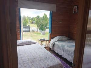 a bedroom with two beds and a large window at Casa Ayuntún in Puerto Montt