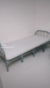 a mattress on a bed frame in a room at Partion Room Rental in Sharjah