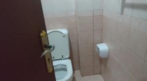 a bathroom with a white toilet in a stall at Partion Room Rental in Sharjah