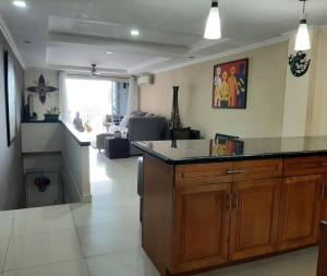 a kitchen with a counter and a living room at Viewscape Condo 3bedrooms in Port-of-Spain