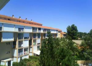 um grande edifício de apartamentos com árvores em primeiro plano em Piscine - mer 5 minutes à pied - sans draps em Argelès-sur-Mer