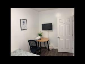 a room with a table and a television and a door at Stylist bedroom central of Baltimore in Baltimore