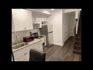 a kitchen with white cabinets and a sink and a microwave at Stylist bedroom central of Baltimore in Baltimore