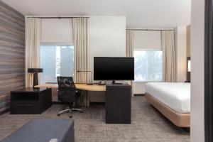 een hotelkamer met een bed en een bureau met een televisie bij Residence Inn Providence Coventry in Spring Lake