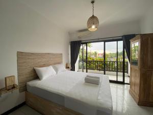 um quarto com uma cama grande e uma varanda em Hotel Summer Of Surf em Ungasan