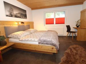 een slaapkamer met een houten bed en 2 ramen bij Ferienhaus Wolf in Tobadill