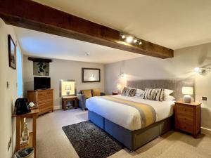 a bedroom with a large bed and a couch at Castle Cottage Inn in Harlech