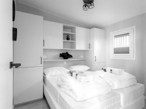 a white bedroom with a bed with white pillows at Top-Nova Scotia in Voorthuizen