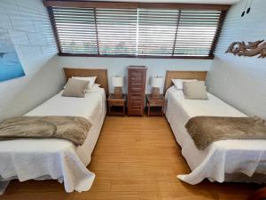 Habitación con 2 camas y 2 lámparas. en Direct Oceanfront Mauna Loa Shores Honu Elua #508 next to Carlsmith Beach park, Hilo HI, en Hilo