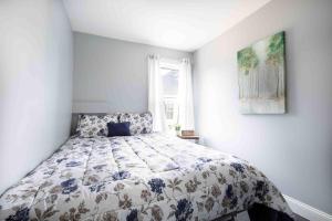 um quarto com uma cama com colcha floral em Elegant 1BR 1 Bath apartment minutes the falls em Niagara Falls