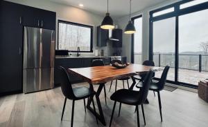 eine Küche mit einem Holztisch und schwarzen Stühlen in der Unterkunft The Golden View - Luxury Cottage in La Conception