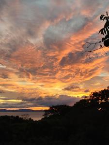 a sunset over the water with clouds in the sky at Finca Mystica in Ometepe