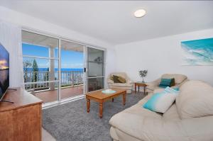 a living room with a couch and a table and a television at Quarterdeck 4 - Lennox Head in Lennox Head