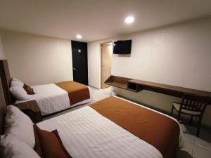 Habitación de hotel con 2 camas y TV en Hotel Plaza Morelos, en Toluca