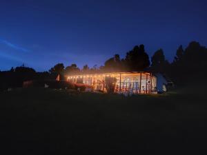 un edificio con luces encendidas en un campo por la noche en Balcones del Lago de Tota, en Sogamoso