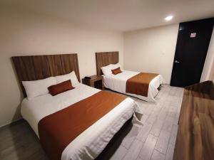 a hotel room with two beds in a room at Hotel Plaza Morelos in Toluca