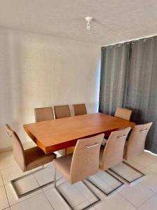 una mesa de madera y sillas en una habitación en Casa con Alberca Privada, en Aguascalientes
