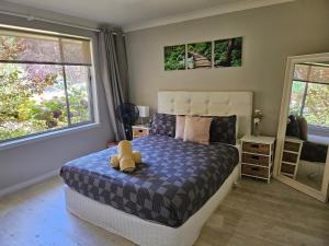 Un dormitorio con una cama con un osito de peluche encima. en Dar Rahah, en Orange