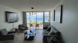 una sala de estar con sofás y vistas al océano. en New! 2 bedroom/bath in Isla Verde, en San Juan