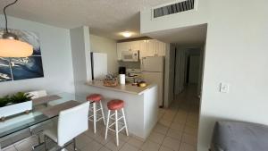 a kitchen with a counter and stools in a room at Beach front 2 bedroom & bath in Isla Verde in San Juan