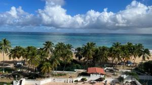 a view of a beach with palm trees and the ocean at Beach front 2 bedroom & bath in Isla Verde in San Juan